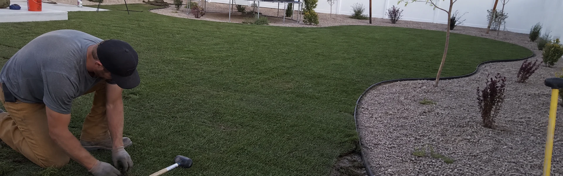 Finished YLC Landscaping back yard in the Tooele Valley with new sod, edged gravel beds and young trees