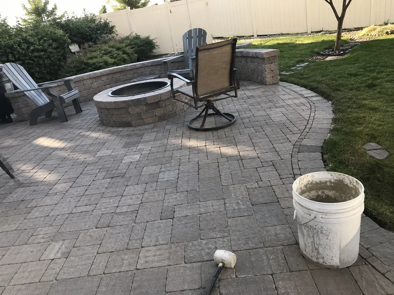 Paver patio with a stone fire pit and seating in a Utah back yard