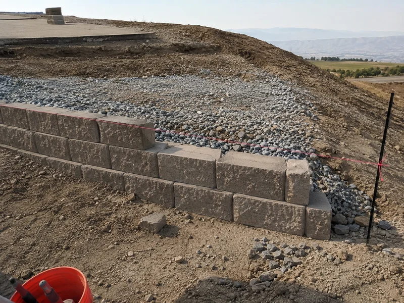 Segmental block retaining wall holding a graded slope on a rural Tooele County lot