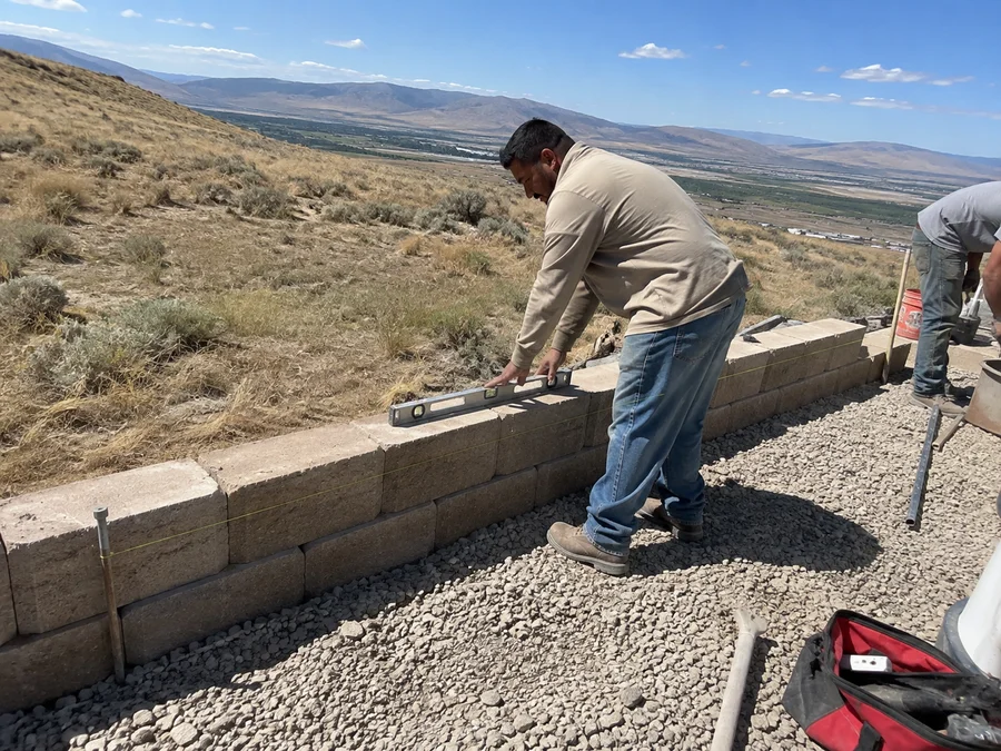 Base course of a segmental block retaining wall being set level on compacted road base