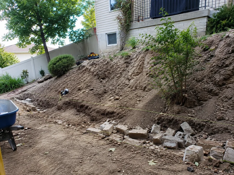 Eroding bare slope in a Utah back yard before a retaining wall is built