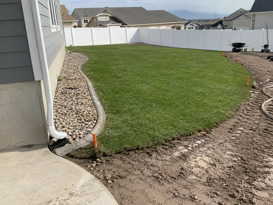 Finished lawn on a correctly graded Utah yard with water running clear of the foundation