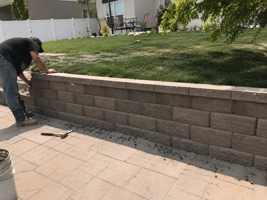 Finished retaining wall with a level usable lawn above and a paver patio below