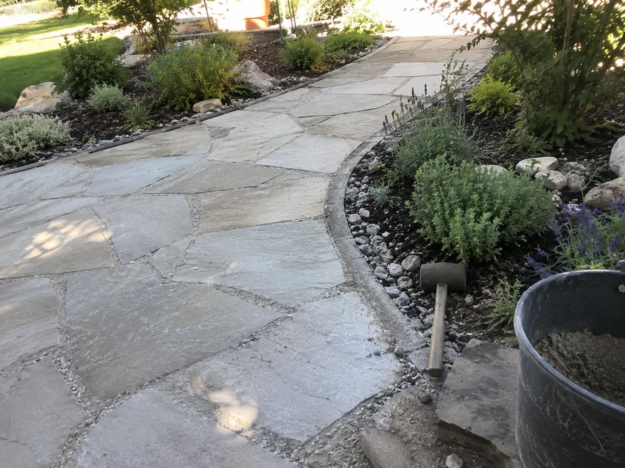 Flagstone walkway curving through a planted Utah garden bed