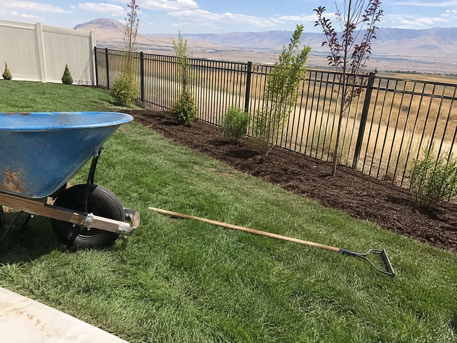 Fresh bark mulch being spread around the base of new plantings