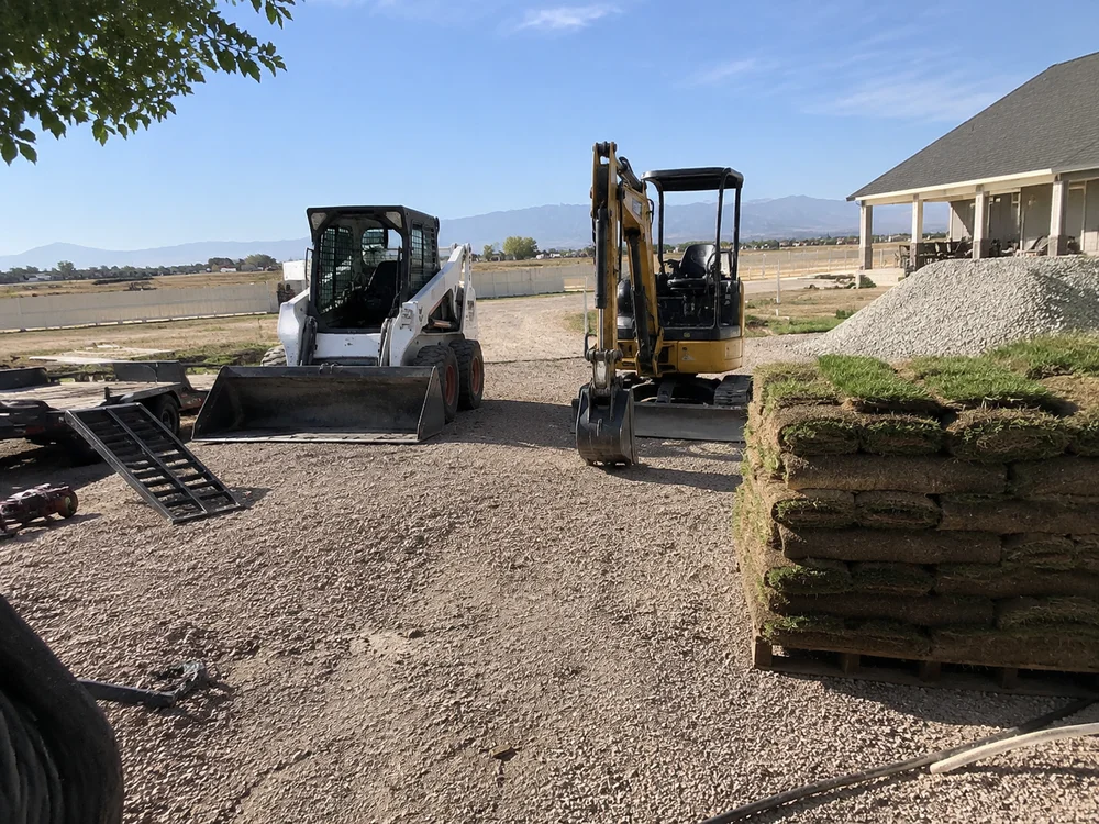 Skid steer and mini excavator at the YLC Landscaping equipment yard in Grantsville, Utah