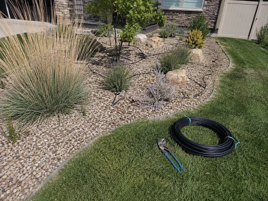 Water-wise Utah bed with drought-tolerant plants, gravel and drip lines beneath