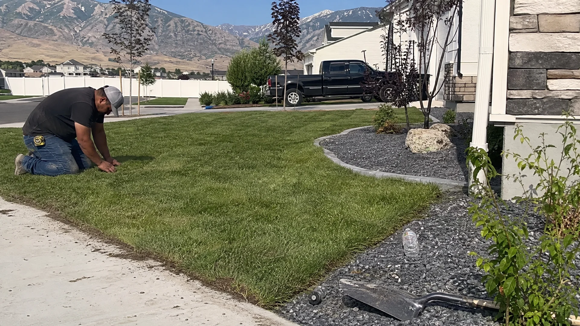 A freshly finished front yard in the Tooele Valley with new sod, young trees and edged gravel beds